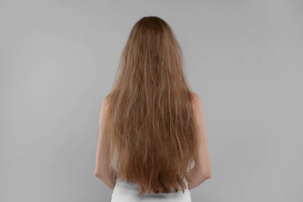 Γυναίκα Ταλαιπωρημένα Μαλλιά Ανοιχτό Γκρι Φόντο Πίσω Όψη — Φωτογραφία Αρχείου