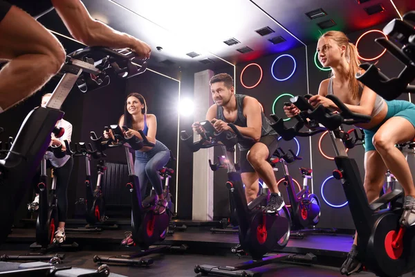 Spor salonunda egzersiz bisikleti eğitimi alan bir grup insan.