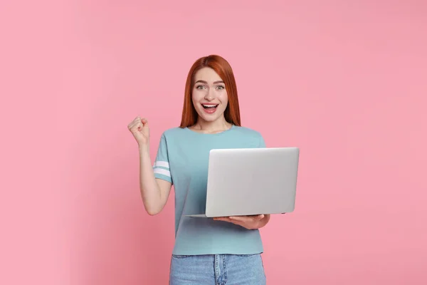 快乐的年轻女人 背景是粉色的笔记本电脑 — 图库照片