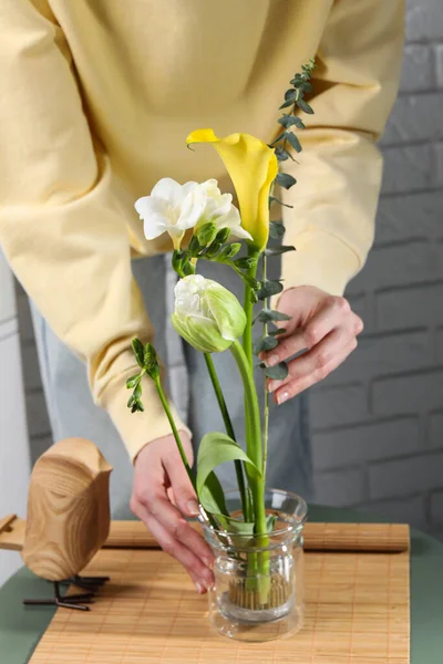 漂亮的Ikebana为时尚的房子装饰 女性在咖啡桌上用鲜花和桉树枝叶创作花卉 — 图库照片