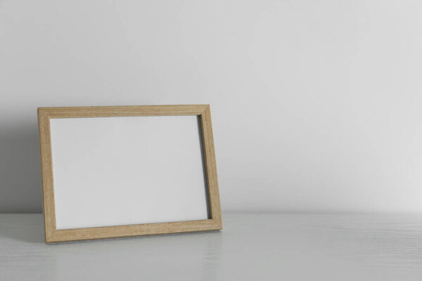 Empty square frame on white wooden surface, space for text