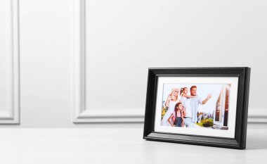 Beyaz ahşap masa üzerinde çerçeveli aile fotoğrafı, metin için boşluk