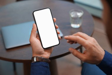 Kafedeki masada akıllı telefon kullanan adam, yakın plan.