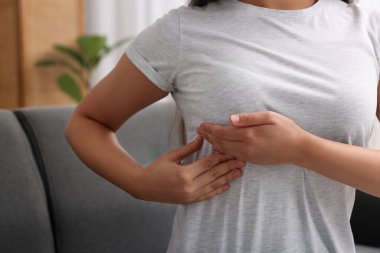 Kadın evinde göğüs muayenesi yapıyor, yakın çekim.