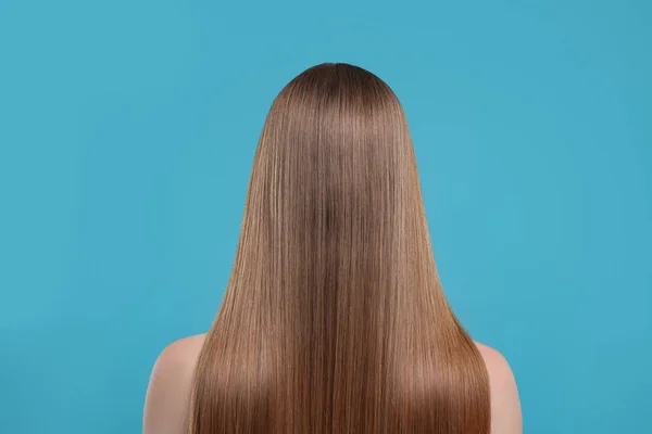 ライトブルーの背景に健康な髪の女性 バックビュー — ストック写真