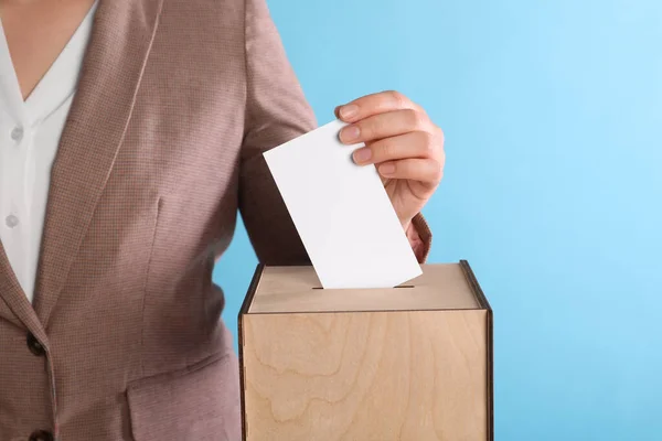 Frau Wirft Ihre Stimme Die Wahlurne Auf Hellblauem Hintergrund Nahaufnahme — Stockfoto
