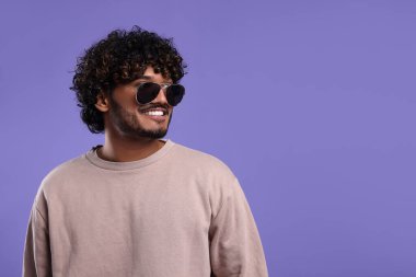 Menekşe arka planda güneş gözlüklü yakışıklı adam, metin için yer