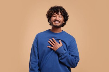 Bej arka planda gülümseyen yakışıklı genç adam, metin için boşluk