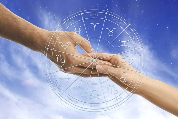 关系和占星术黄道带轮和男女手牵手冲天的照片 — 图库照片