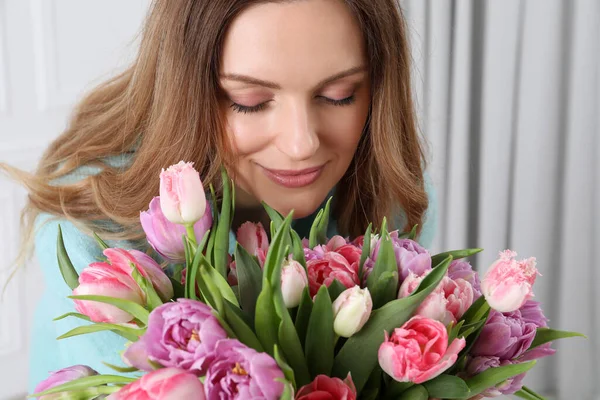 屋内で美しいチューリップの花束を持つ幸せな若い女性 — ストック写真