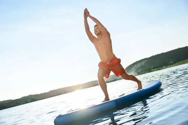 Man Utövar Yoga Ljusblå Sup Ombord Floden Vid Solnedgången — Stockfoto