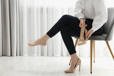 Kadın yüksek topuklu ayakkabıya ortopedik taban takıyor. Ayak bakımı