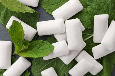 Lezzetli beyaz sakız ve nane yaprakları gri arka planda, düz yerde
