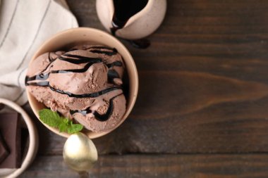Tahta masada servis edilen bir kase lezzetli çikolatalı dondurma. Metin için boşluk