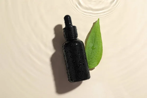 ベージュの背景 平らな層の水の化粧品オイルそして緑の葉のびん — ストック写真