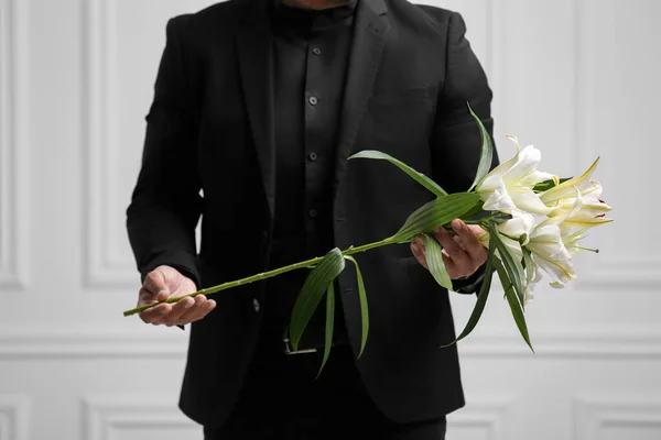 Muž Liliovými Květy Bílé Zdi Detailní Záběr Pohřební Obřad — Stock fotografie