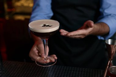 Barda Espresso Martini içen barmen, yakın plan. Alkol kokteyli.