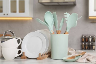 Evdeki beyaz masada farklı mutfak malzemeleri var.