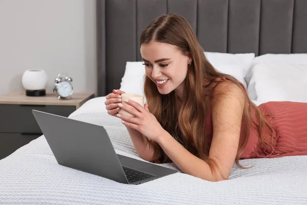 Щаслива Жінка Чашкою Напою Ноутбуком Ліжку Спальні — стокове фото