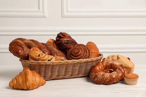 Wicker Basket Different Tasty Freshly Baked Pastries White Wooden Table — Stock Photo, Image