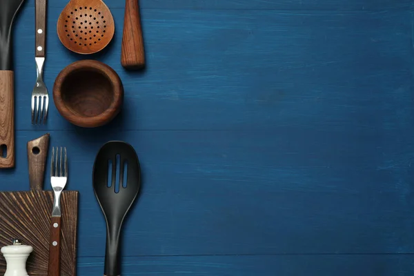 青い木のテーブルの平らな層の異なった台所用品のセット テキスト用スペース — ストック写真
