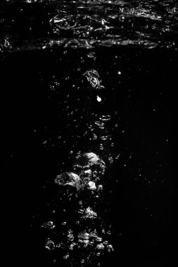 Siyah zemin üzerinde suda hava kabarcıkları