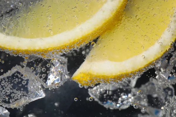 Saftige Zitronenscheiben Und Eiswürfel Sodawasser Vor Schwarzem Hintergrund Nahaufnahme — Stockfoto