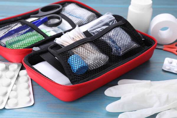 First aid kit on blue wooden table, closeup