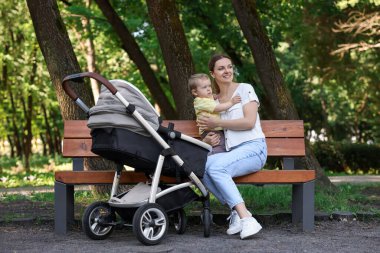 Parktaki bankta oturan sevimli çocukla mutlu bir dadı.