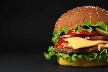 Köfteli leziz burger ve koyu arkaplanda marul, mesaj için yer.