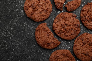 Gri desenli masa üzerinde lezzetli çikolatalı kurabiyeler, düz yatak. Metin için boşluk