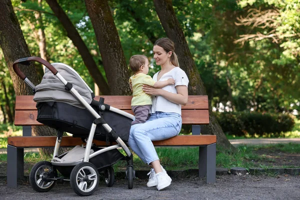 Parktaki bankta oturan sevimli çocukla mutlu bir dadı.