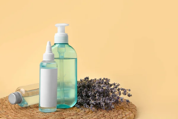 Bottles with cosmetic products and dried lavender flowers on beige background. Space for text