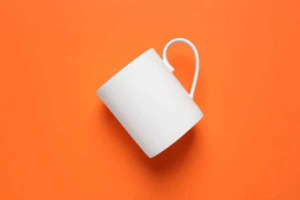 オレンジ色の背景 トップビューの1つの白い陶磁器のマグ — ストック写真