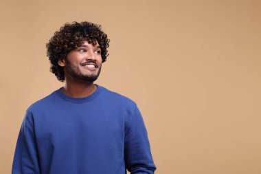 Bej arka planda gülümseyen yakışıklı genç adam, metin için boşluk