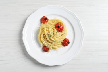 Beyaz ahşap masa üzerinde domatesli ve peynirli capellini, üst manzara. Makarna yemeğinin enfes sunumu