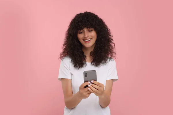 Ευτυχισμένη Νεαρή Γυναίκα Που Χρησιμοποιεί Smartphone Ροζ Φόντο — Φωτογραφία Αρχείου