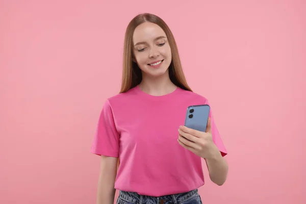 Ευτυχισμένη Νεαρή Γυναίκα Που Χρησιμοποιεί Smartphone Ροζ Φόντο — Φωτογραφία Αρχείου