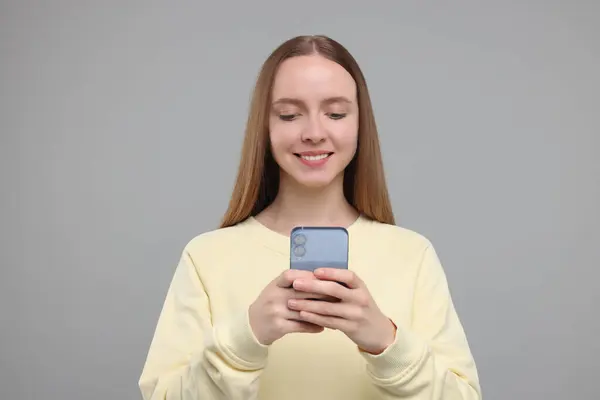 Glückliche Junge Frau Mit Smartphone Auf Hellgrauem Hintergrund — Stockfoto