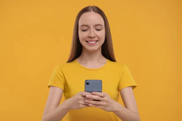 Glückliche Junge Frau Mit Smartphone Auf Gelbem Hintergrund — Stockfoto