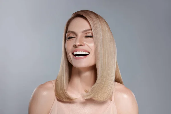 Portret Atrakcyjnej Kobiety Blond Włosami Uśmiechniętymi Szarym Tle — Zdjęcie stockowe