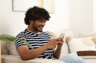 Odada akıllı telefon kullanan yakışıklı adam, mesaj için boşluk