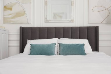 Yatak odasında yastıklar olan büyük, rahat bir yatak. İç tasarım