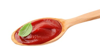 Lezzetli ketçaplı ahşap kaşık ve beyaz üzerine izole edilmiş fesleğen