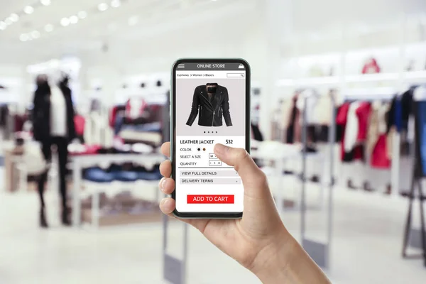Woman visiting shop to take ordered jacket indoors, closeup. Online store website on device screen