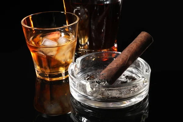Verbrannte Zigarre Aschenbecher Und Whiskey Auf Schwarzer Spiegeloberfläche Nahaufnahme — Stockfoto