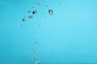 Açık mavi arkaplanda suda hava kabarcıkları