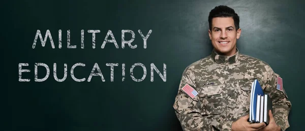 Military education. Cadet with notebooks near green chalkboard