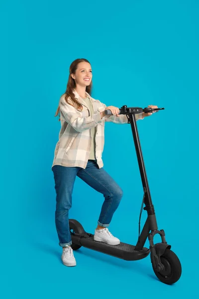 Mujer Feliz Con Scooter Eléctrico Moderno Sobre Fondo Azul Claro —  Fotos de Stock