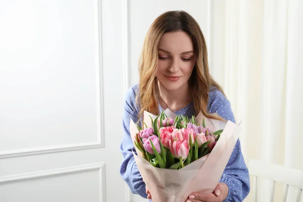 屋内で美しいチューリップの花束を持つ若い女性 テキスト用スペース — ストック写真